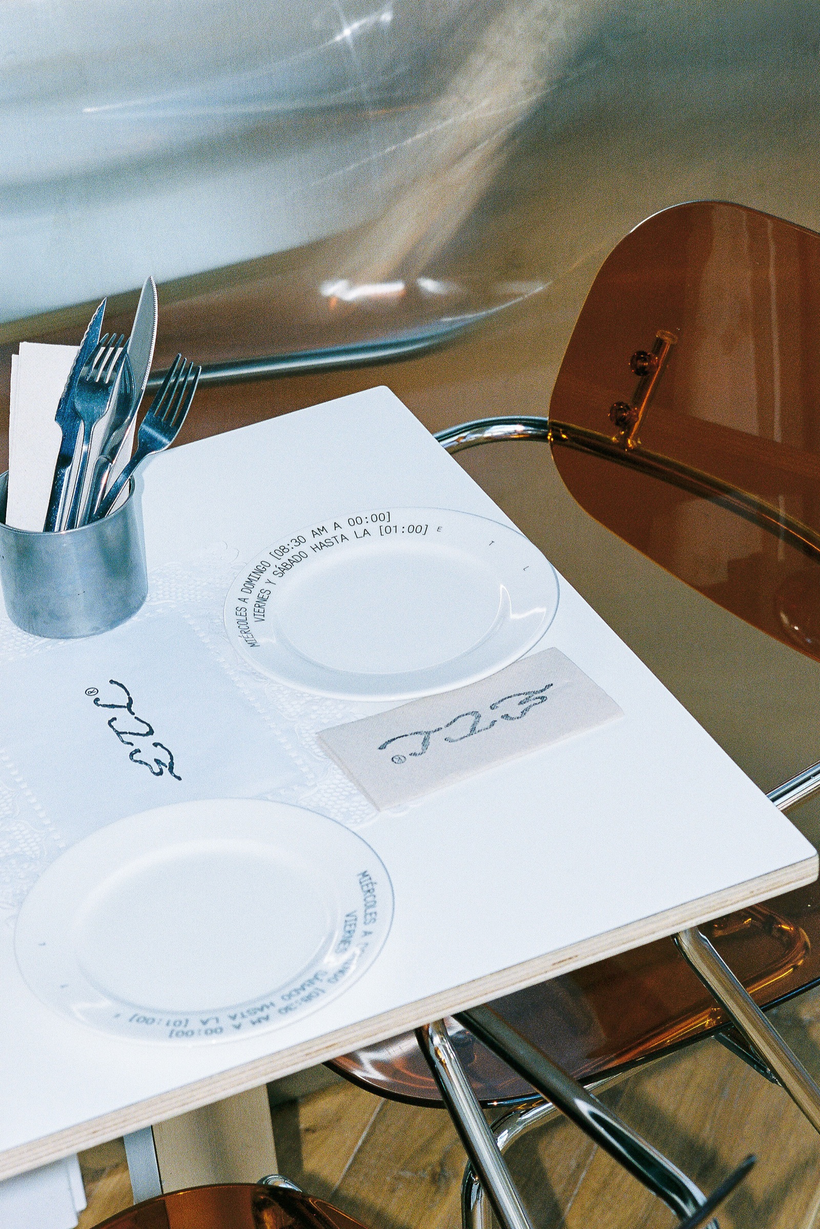 Table setting with ceramic plates carrying ETL hours printed around the rim.